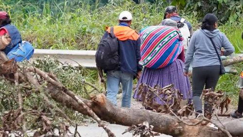 Viajeros caminan con equipaje por bloqueos en la ruta a Caranavi